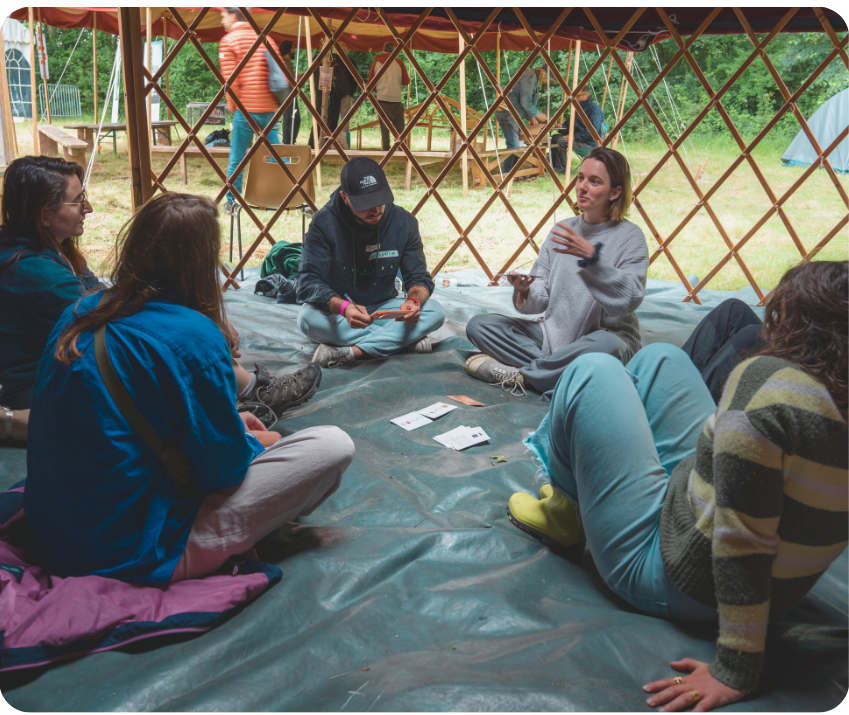 5 personnes assises par terre jouant a habitats heureux